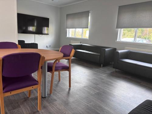 a living room with a table and chairs and a couch at Garnock 3 in Beith