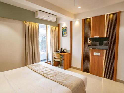 a hotel room with a bed and a television at Hotel Supreme Inn in Thane