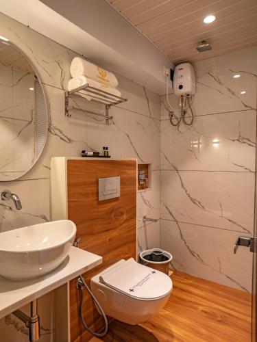 a bathroom with a white toilet and a sink at Hotel Supreme Inn in Thane