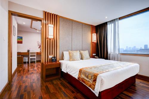 a bedroom with a large bed with a large window at Dancenter Bangkok Travellers Hotel in Bangkok