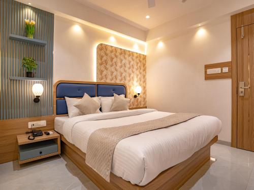 a bedroom with a large bed with a blue headboard at Hotel Supreme Inn in Thane