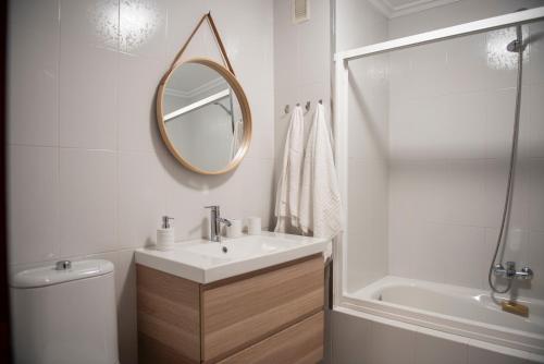a white bathroom with a sink and a mirror at Ideal Turismo Ribeira Sacra in Chantada