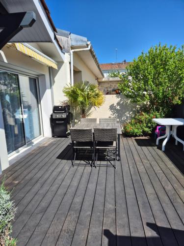 a wooden deck with a table and chairs on it at La Gujannaise in Gujan-Mestras