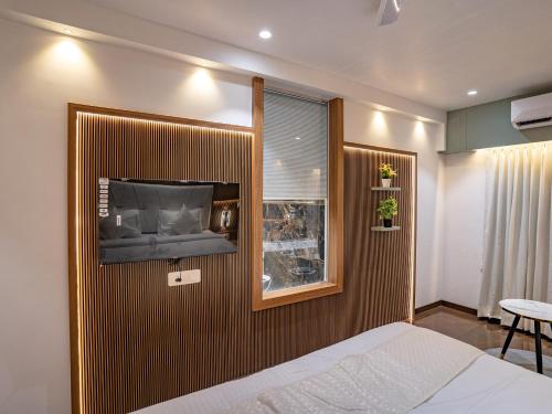 a bedroom with a bed and a tv on a wall at Hotel Supreme Inn in Thane