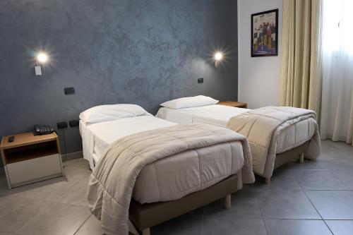 a room with two beds and a table at Hotel Saturday in Palma Campania