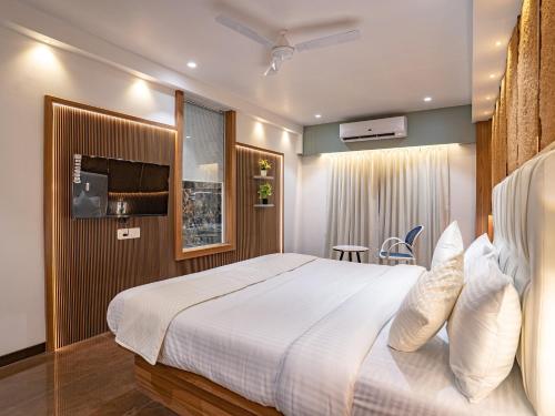 a bedroom with a large white bed in a room at Hotel Supreme Inn in Thane