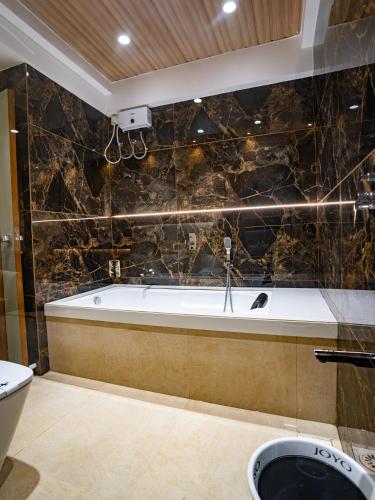 a bathroom with a bath tub and a toilet at Hotel Supreme Inn in Thane