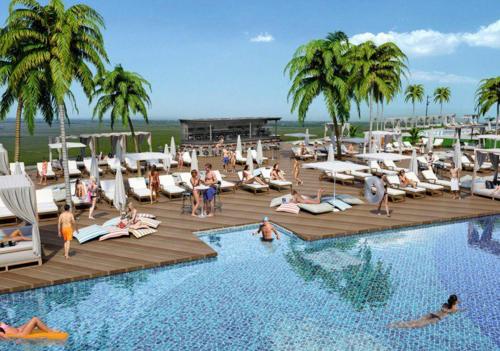 a group of people sitting around a pool at a resort at Sunny escape Holiday apartment in İskele