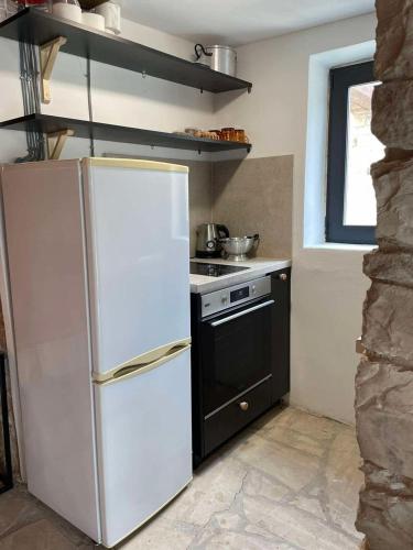 a kitchen with a white refrigerator and a stove at The Hideaway in Arminou