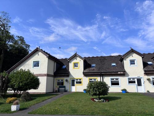 a white house with a black roof at Cunninghame 3 in Beith
