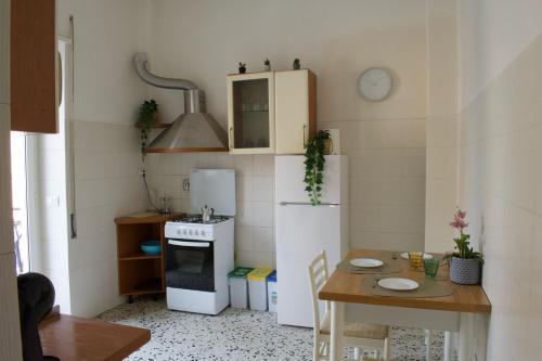 a small kitchen with a white refrigerator and a table at Fly Home - 15 minutes to ROME in Ciampino
