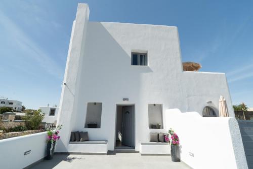 a white building with flowers in vases at Dauti Gold Suites in Vóthon