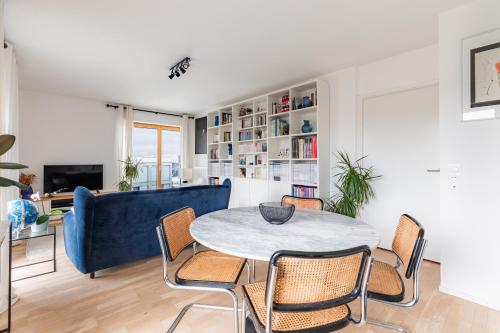 un salon avec un canapé bleu et une table dans l'établissement Magnifique appartement Paris, bord du canal, à Pantin
