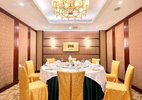 a dining room with a table and chairs and a chandelier at Grand Dragon Hotel in Macau