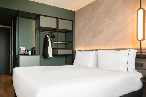 a bedroom with a large white bed and a closet at Novotel Valencia Lavant in Valencia
