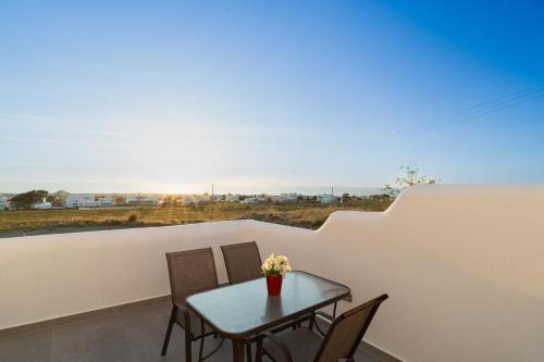 a table and chairs on a balcony with a view at Dauti Gold Suites in Vóthon