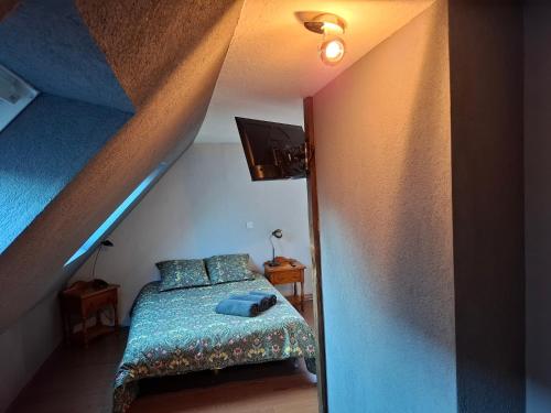 a bedroom with a bed with a blue blanket at Chambre d'hotes au coeur du village in Reichshoffen