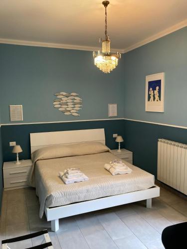 a bedroom with a bed with blue walls and a chandelier at Oltre il Blu in La Spezia