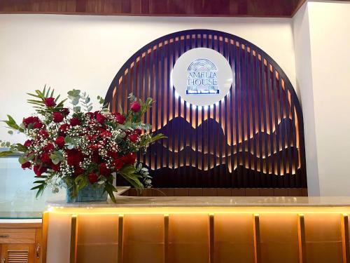 a stage with a vase of flowers on a table at Amelia House - Boutique Hotel in Khu Chi Lăng