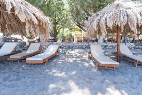 a group of chairs and umbrellas on a beach at West nest caravan in Sfinárion