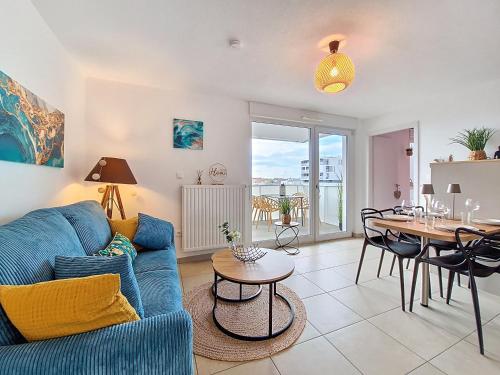 un salon avec un canapé bleu et une table dans l'établissement Chez Lady Mag - Neuf - Confort - Parking - Proche centre-ville - Tram, à Strasbourg