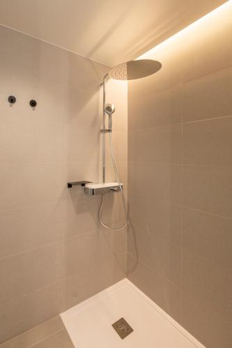 a bathroom with a shower with a shower head at Novotel Valencia Lavant in Valencia