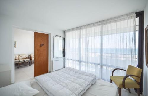 a bedroom with a bed and a large window at Chez Alain - Confortable appartement et vue à couper le souffle in La Grande-Motte