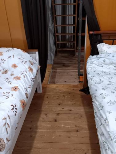 two beds sitting next to each other on a wooden floor at Ikebukuro sta. 10mins walk. Rough style 88㎡ House in Tokyo