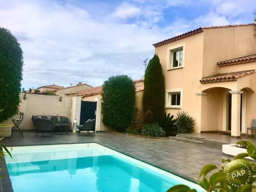 une maison avec une piscine dans la cour dans l'établissement Villa Douce Vague - Le Grau du Roi, au Grau-du-Roi