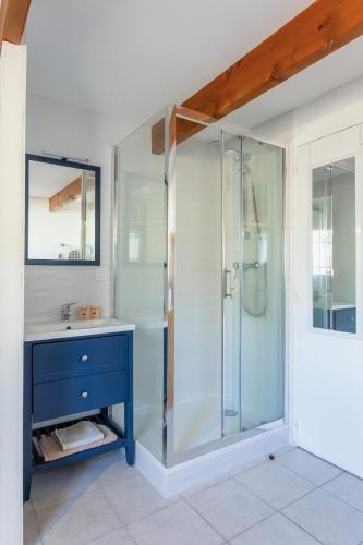 La salle de bains est pourvue d'une douche en verre avec un lavabo bleu. dans l'établissement Villa Douce Vague - Le Grau du Roi, au Grau-du-Roi