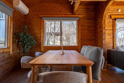a dining room with a wooden table and chairs at Calm villa 富士山中湖 in Yamanakako