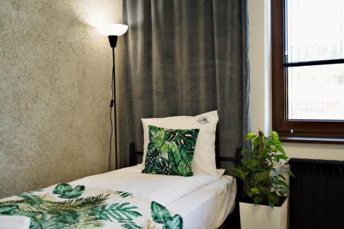 a bedroom with a bed with a pillow and a window at Apartamenty na Zatorskiej by Housine in Zator