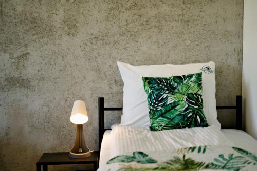 a bed with a pillow and a lamp on a table at Apartamenty na Zatorskiej by Housine in Zator