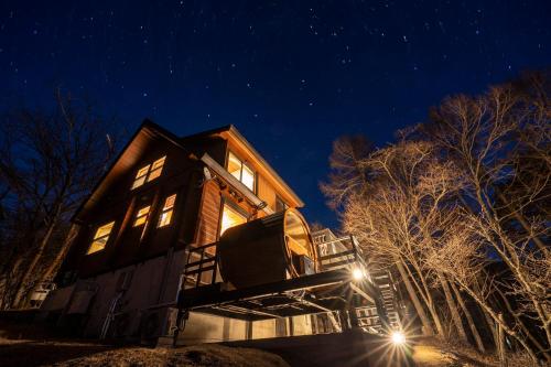 a house sitting on top of a hill at night at Calm villa 富士山中湖 in Yamanakako
