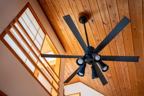 a ceiling fan hanging from a wooden ceiling at Calm villa 富士山中湖 in Yamanakako