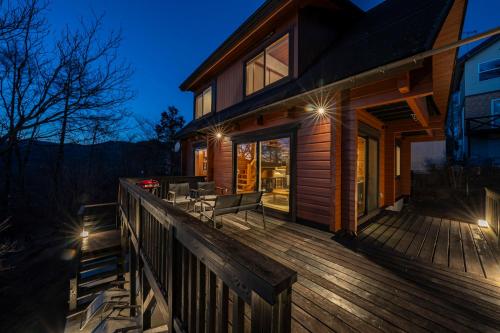 a house with a wooden deck at night at Calm villa 富士山中湖 in Yamanakako