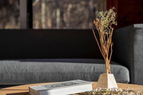 a book and a vase with flowers on a table at Calm villa 富士山中湖 in Yamanakako