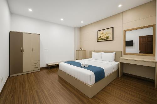 a bedroom with a large bed and a mirror at Tuan Thuy Hotel in Da Lat