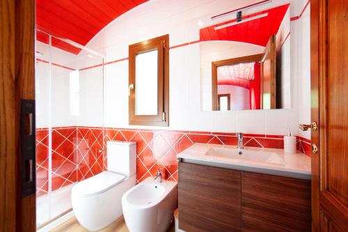 a bathroom with a toilet and a sink and a mirror at Poggio Diavolino - Suvereto in Suvereto