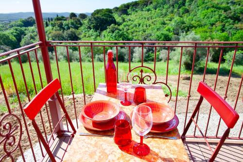 a table with plates and wine glasses on a balcony at Poggio Diavolino - Suvereto in Suvereto