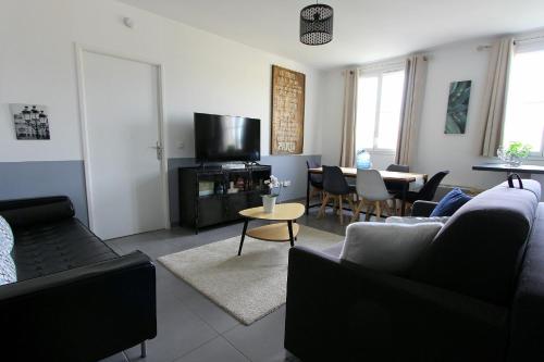 un salon avec un canapé, une télévision et une table dans l'établissement TAGE3 - Disneyland Paris & Val d'Europe pour 6 voyageurs, à Serris