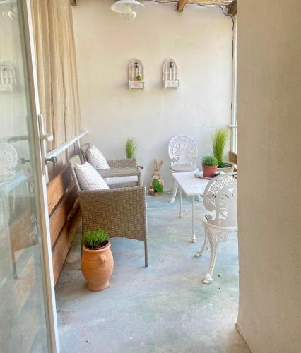 a patio with chairs and a table with plants at Dinateli Houses - Live like a local in Corfu in Kastellánoi