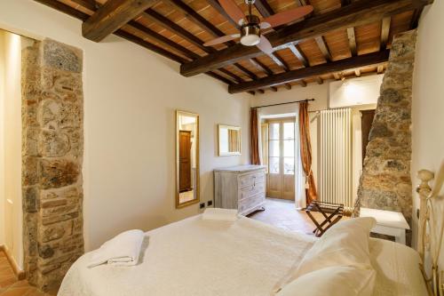 a bedroom with a bed and a stone wall at Relais La Costa Historical Residence in Monteriggioni