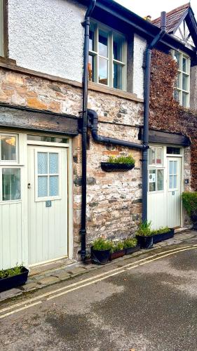 a stone building with two garage doors on a street at Kings Arms Hotel in Kirkby Lonsdale