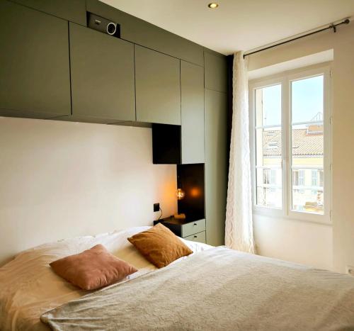une chambre avec un lit blanc avec une fenêtre dans l'établissement Appartement rénové, 1 chambre, centre historique, à Hyères