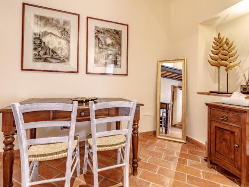 a dining room with a table and chairs and a mirror at Relais La Costa Historical Residence in Monteriggioni