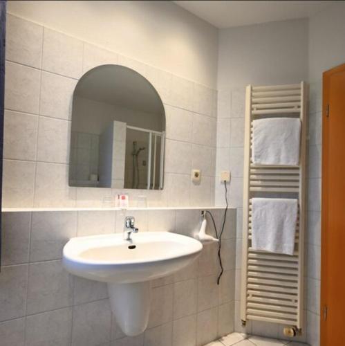 a bathroom with a sink and a mirror at Gästehaus Hankhausen in Rastede