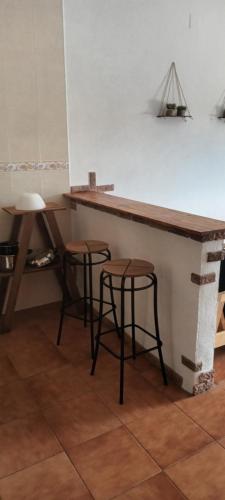 a counter with two stools next to a table at Bungalows Sierra San Benito in Cala
