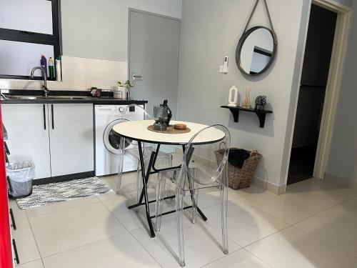 a kitchen with a table and a washing machine at Sarona LoLa A103 Kappa in Gaborone