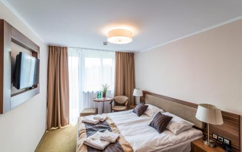 a hotel room with a bed and a television at Hotel Polanica Resort & Spa in Polanica-Zdrój